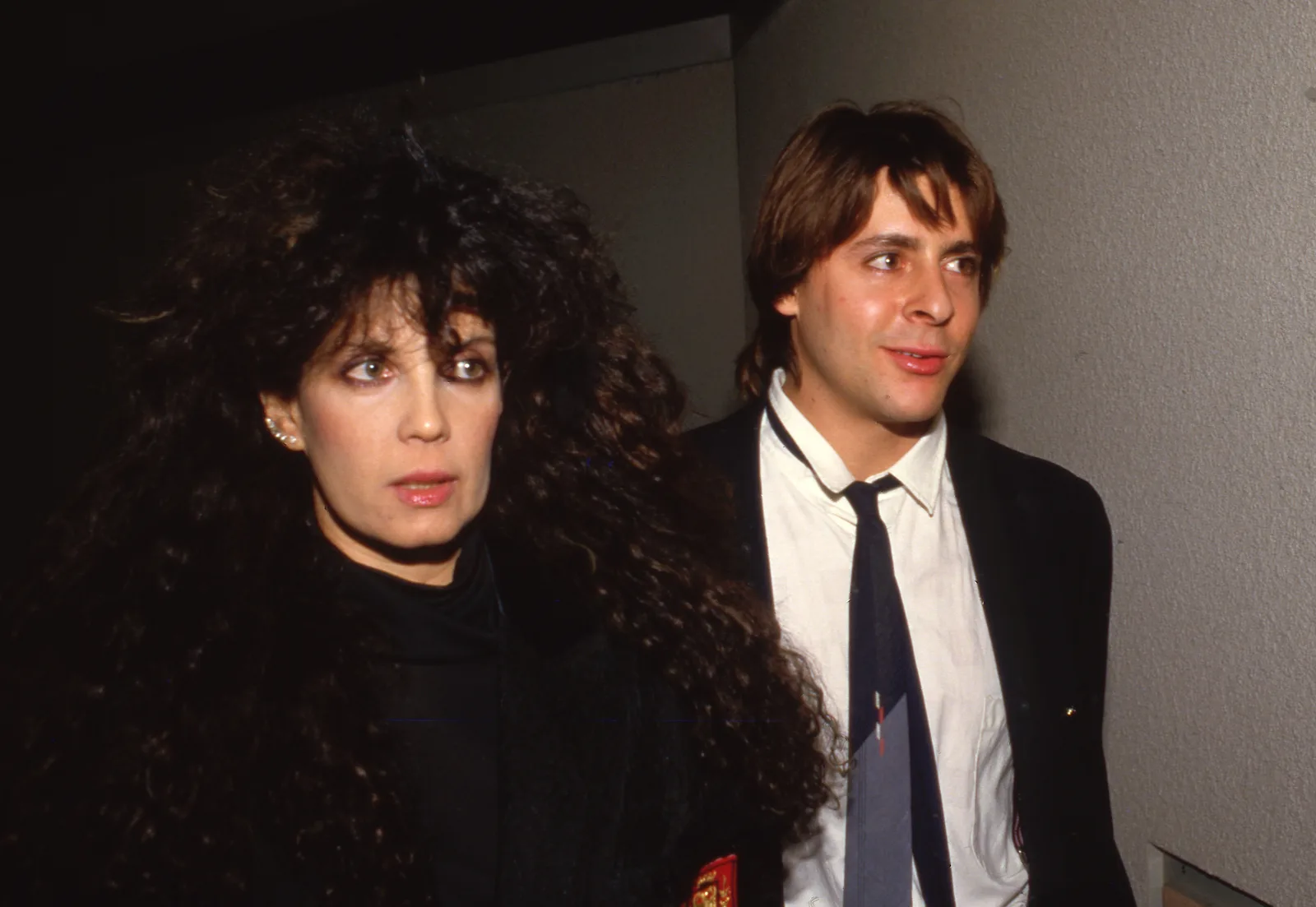 Stepping out in a sharp suit alongside jewelry designer Loree Rodkin on March 26, 1987, catching the flashbulbs at an event during the height of his mid-eighties stardom.