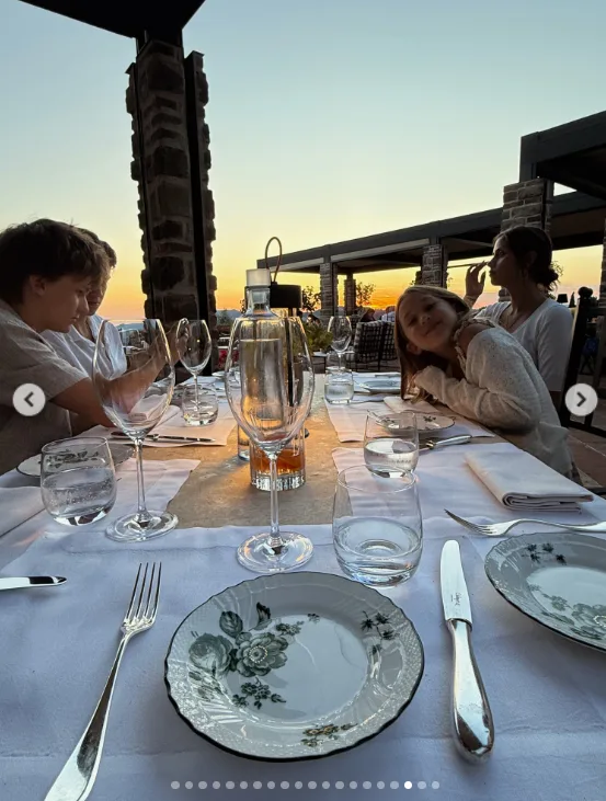 Another photo showed the family at dinner as the sun set. The table was set with plates and glasses, while the orange sky glowed behind the restaurant.