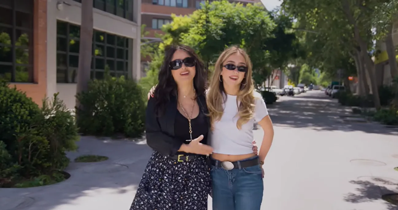 Salma and Valentina walked arm in arm before continuing their vintage-shopping trip. Their contrasting outfits reflected the style differences they discussed, with Salma choosing a dark floral skirt and Valentina wearing a white cropped T-shirt with loose jeans.