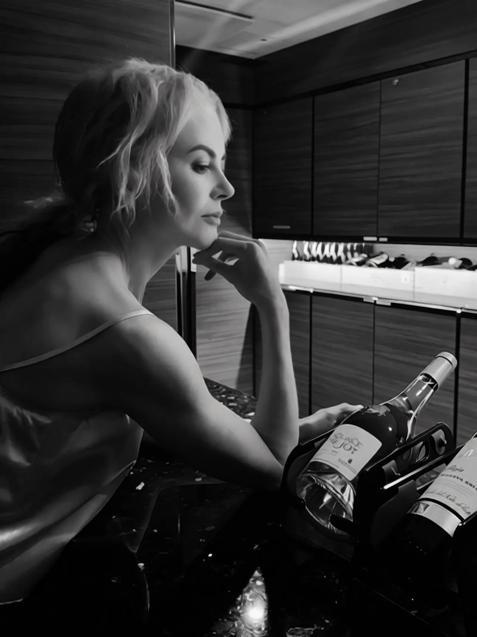 Kidman serves pure moody elegance in a atmospheric black-and-white portrait taken inside the ship's bar. Resting her chin on her hand in a delicate silk tank, she posed alongside fine wine bottles.