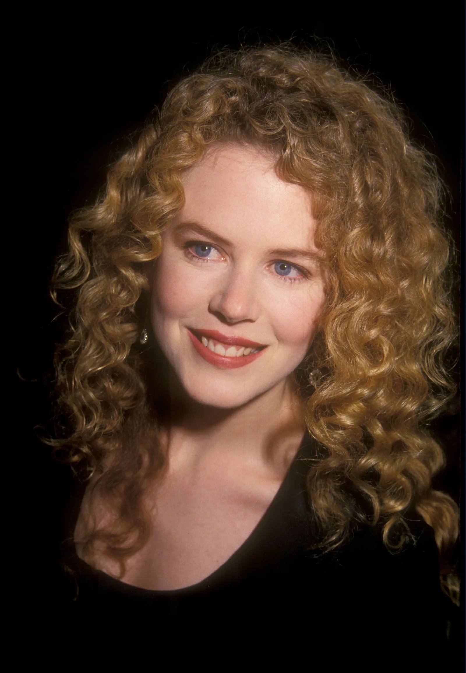 Nicole Kidman with brushed-out copper curls at the "Far and Away" premiere in Beverly Hills. Her hair is voluminous and parted to the side, with defined texture from root to tip.