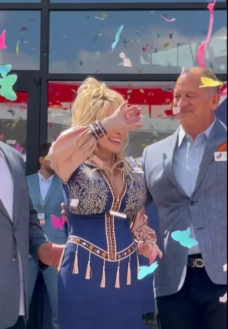 Dolly Parton smiles as confetti falls around her during the grand opening celebration, with her appearance sparking a wave of supportive and concerned reactions across social media.