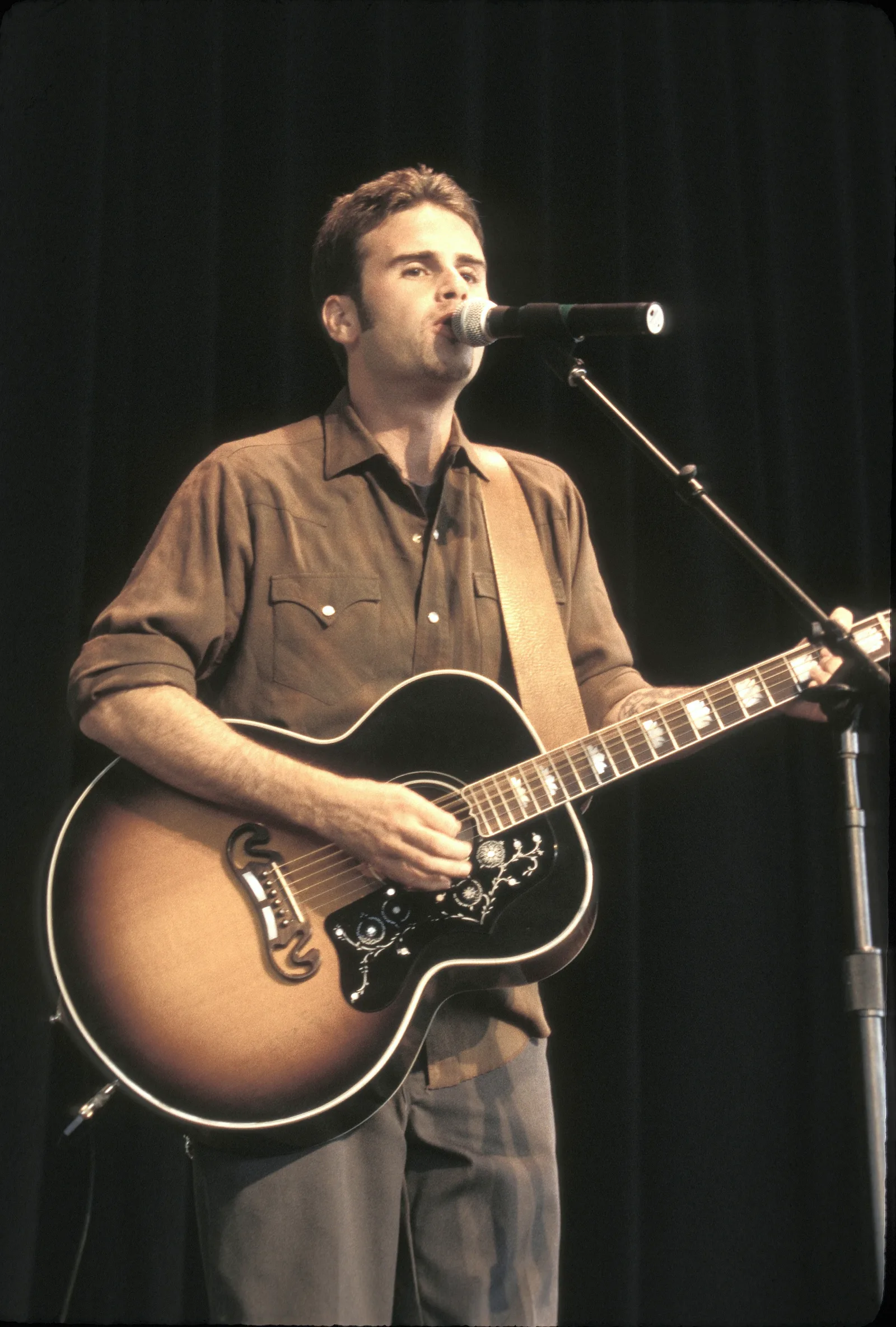 The former star performs with a guitar years after first picking up the instrument at age 12. The future actor once said music—not acting—was always his first love.