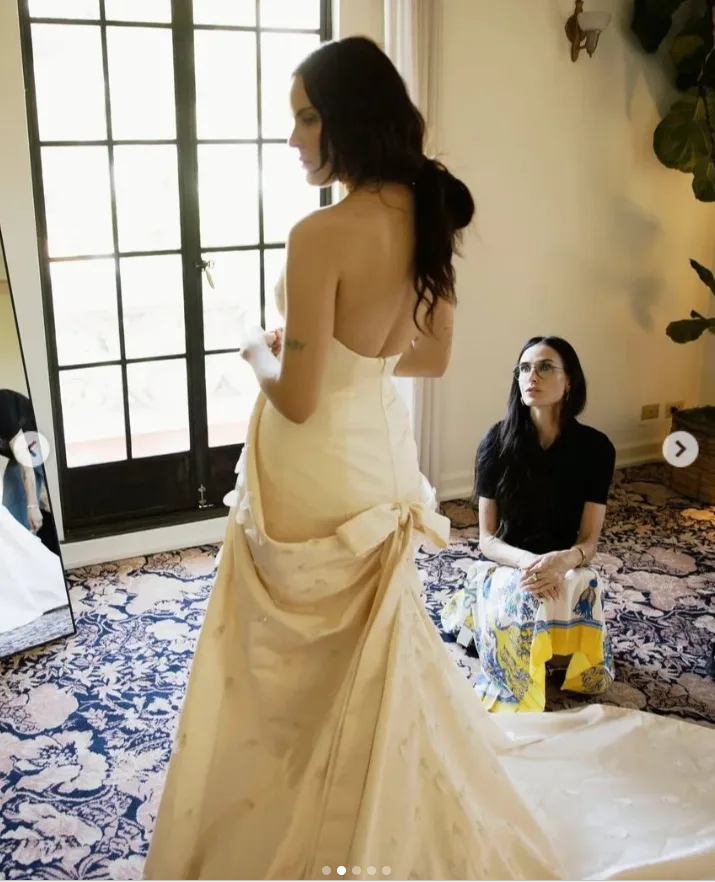 Tallulah Willis gives a first full look at the back of her custom Balenciaga wedding gown, revealing its dramatic open back, sweeping train and oversized bow during her final fitting.