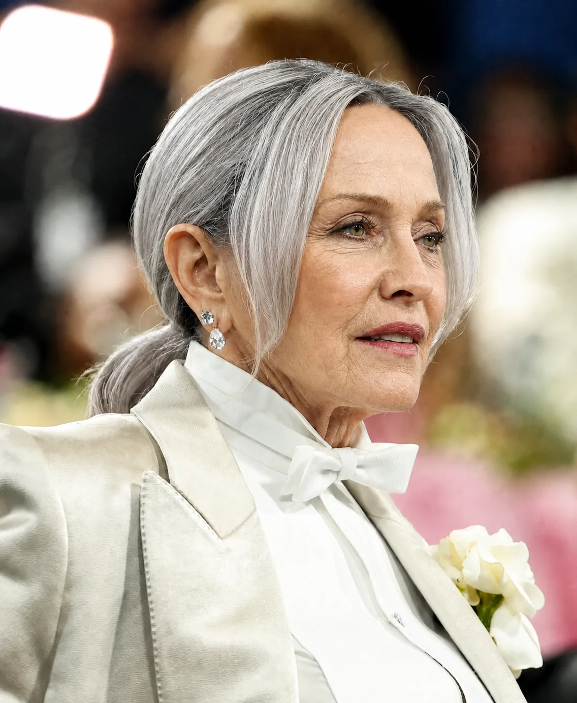 The AI-altered version preserves Madonna's white formal ensemble, jewelry and pose while reimagining her with gray hair and changes to her facial and neck appearance.