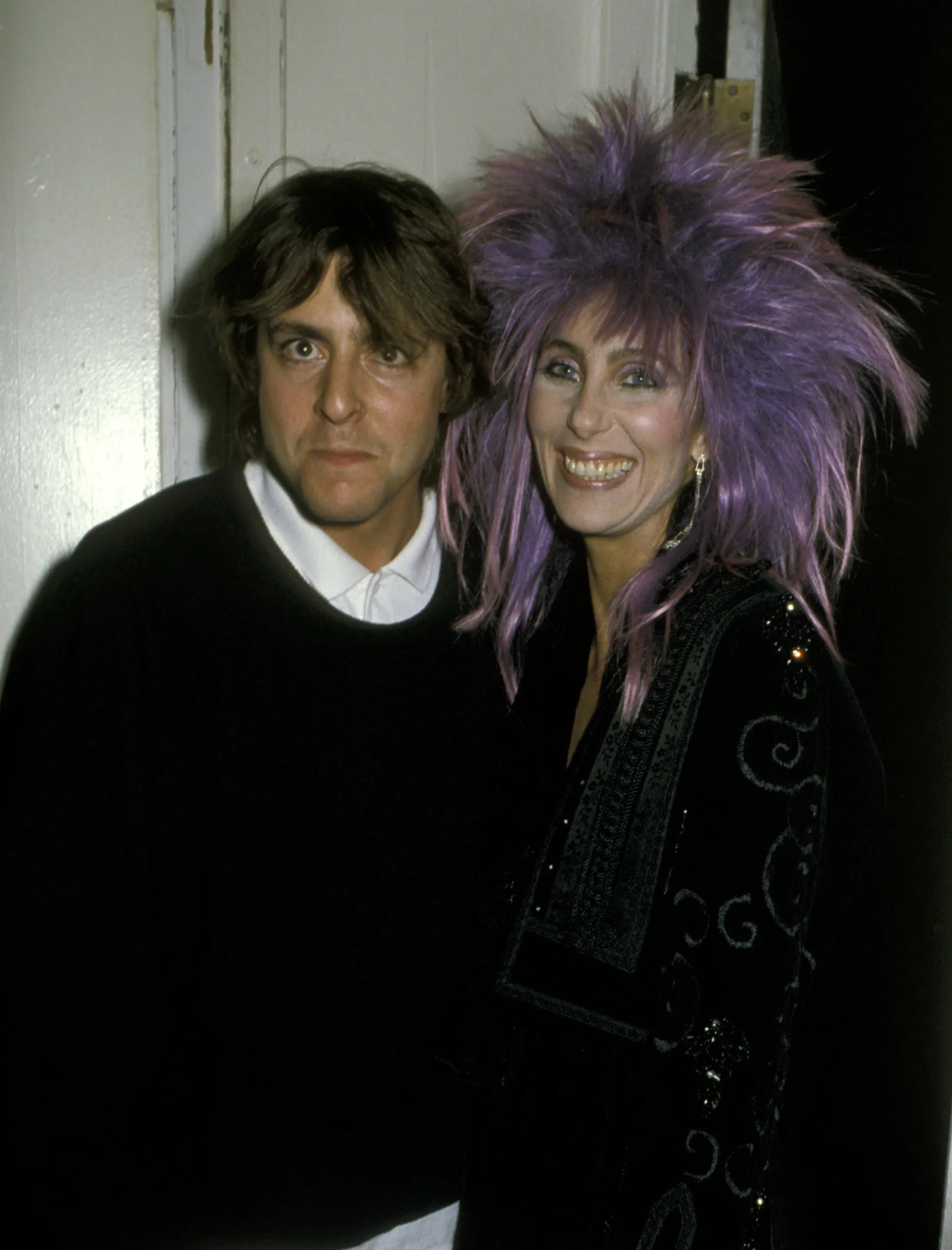 Making a memorable red carpet appearance alongside music icon Cher at the 1985 Los Angeles premiere of "White Nights," the rising actor flashed a playful, wide-eyed expression beside the superstar's striking spiky purple hair.