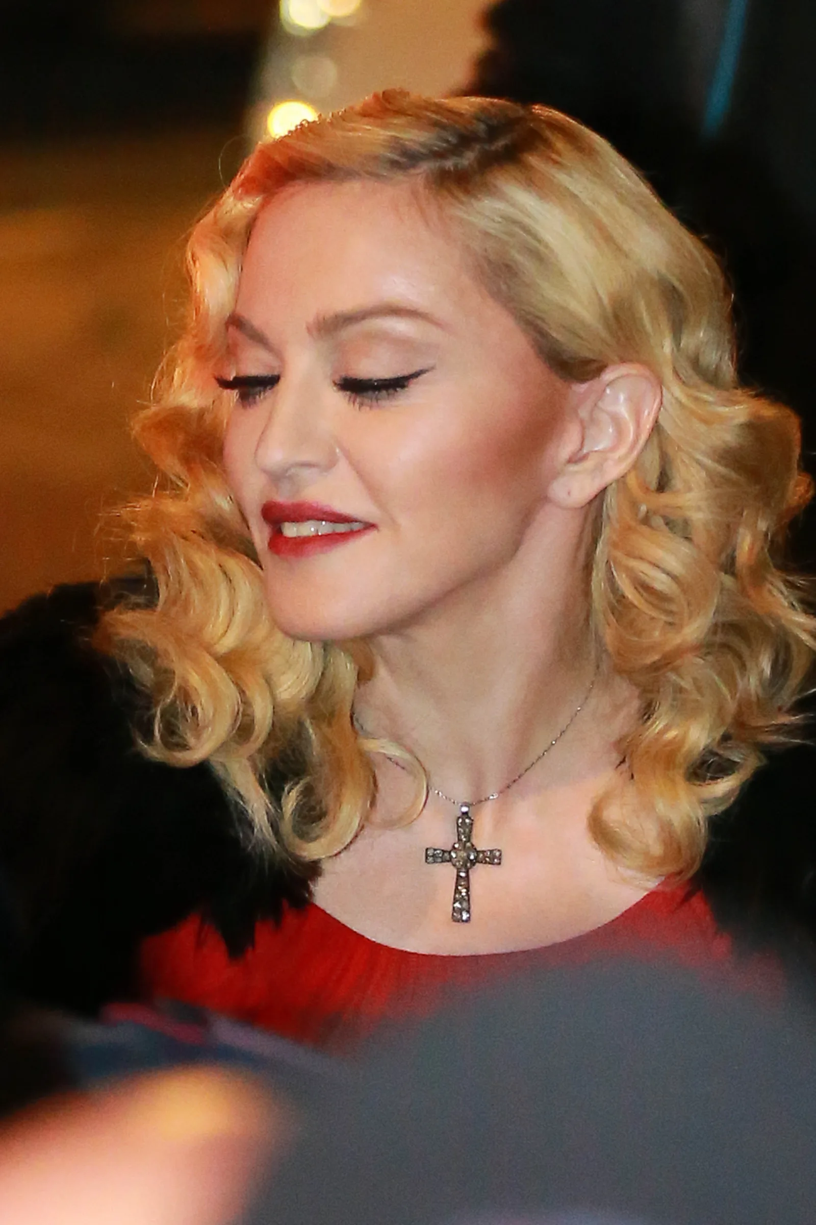 Madonna arrives in Milan on March 1, 2015, while promoting her album "Rebel Heart." She was photographed with curled blond hair and red lipstick during the promotional appearance.