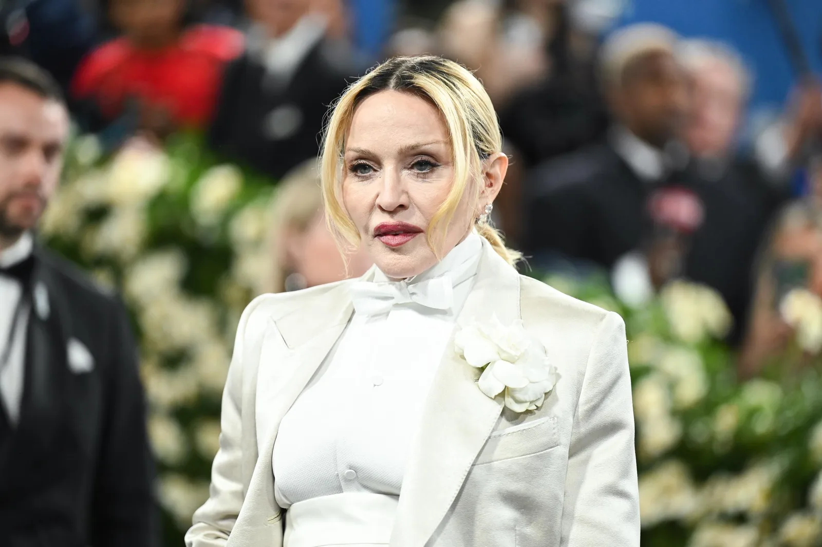 Madonna attends the 2025 Met Gala at the Metropolitan Museum of Art in New York City on May 5. She arrived in an all-white tailored look featuring a high-neck shirt, bow tie, structured jacket, and floral detail.