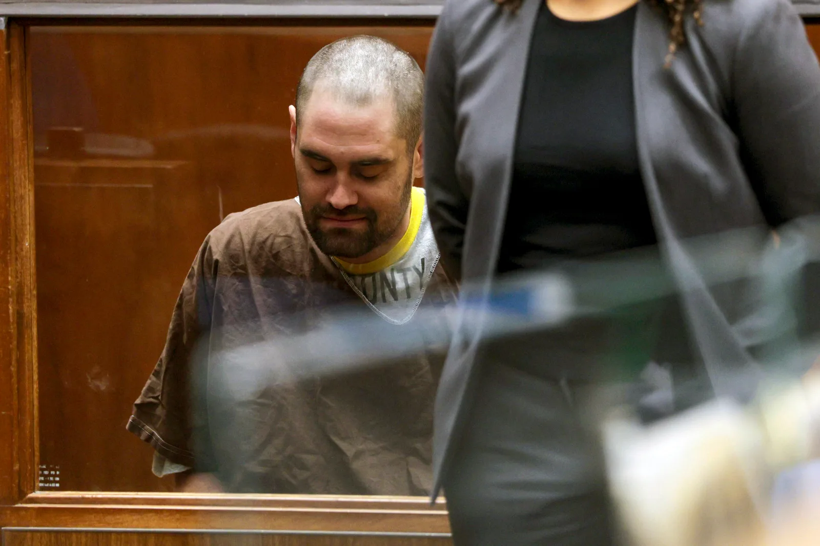 Nick Reiner lowers his head while seated beside Deputy Public Defender Kimberly Greene during court proceedings in Los Angeles