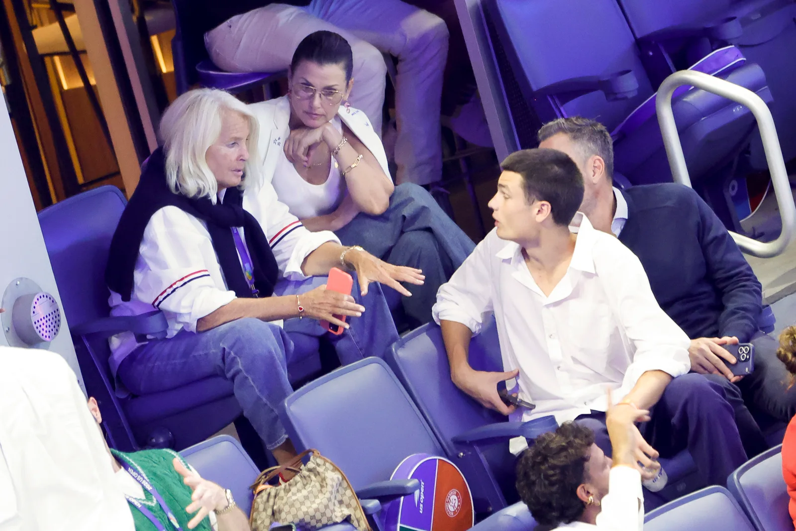 Bridget Moynahan and her son Jack sit together during the 2026 US Open on August 30, 2026, as they chat with fellow spectators in the stands.